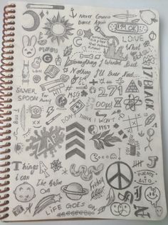 a notebook covered in doodles and writing on it's side, with various symbols