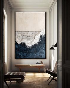 a painting hanging on the wall next to a bench in a room with wooden floors