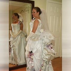 the bride is looking at herself in the mirror