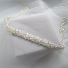 a white wedding garter with pearls on it