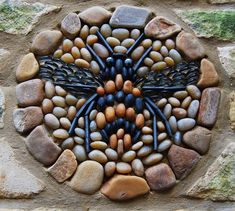 a dragonfly made out of rocks and stones on a stone wall