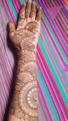 a woman's hand with henna tattoos on it