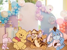 winnie the pooh and friends birthday party decorations with balloons, streamers and balloon arch