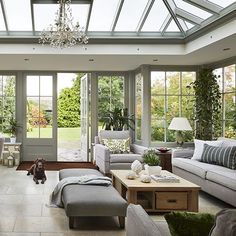 a living room filled with lots of furniture and windows