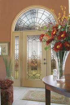 a vase filled with flowers sitting on top of a table in front of a door