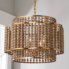 a chandelier made out of wood beads hanging from a ceiling in a room