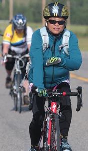 three bicyclists are riding down the road in their helmets and vests