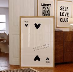 three framed pictures on the wall in a room with wood flooring and wooden furniture