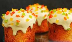 three cupcakes with white frosting and sprinkles on a plate