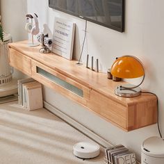 a flat screen tv mounted to the side of a wall next to a wooden shelf