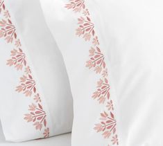 two white pillows with pink leaves on them