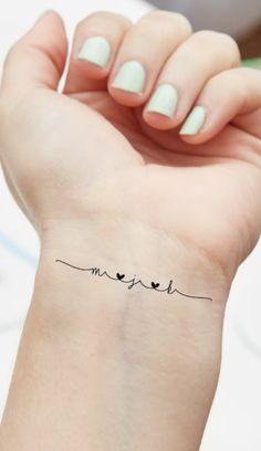 a woman's arm with a small tattoo on the wrist that says love and birds