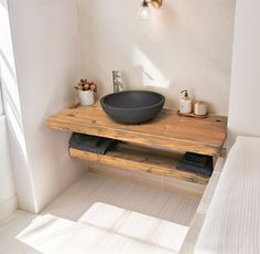 a bathroom sink sitting on top of a wooden counter