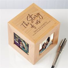 a wooden box with two photos on it and a pen sitting next to the box