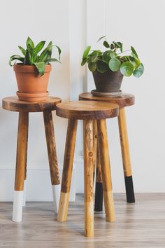 two small wooden stools with plants on them