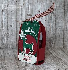 a wine bottle in a christmas card box with a reindeer on it's back