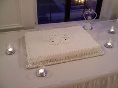 a square cake on a table with candles