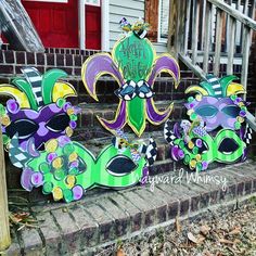 three mardi gras masks are sitting on the steps in front of a house