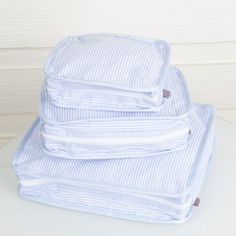 stack of folded blue and white shirts sitting on top of each other