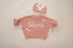 Check out our unique collection of hand-embroidered custom baby/toddler sweaters!  All are super soft, 100% cotton oversized sweaters with distinct heirloom quality hand embroidery - meticulous in the smallest details, featuring your little one's name or any other decor symbols/pattern that you can think of! These sweaters are perfect gifts for any occasion - baby showers, holidays, milestone photos, welcome parties, birthday surprises, etc. Add-on: please message me for more details Notes: Colors may appear slightly different on each device due to lighting and display settings. Please take this into consideration. Care instructions: - This can be machine-washed (gentle care mode) or hand wash - To preserve the quality of the sweater and keep it in good shape for a long time, natural dry i Knit Toddler Sweater, Hand Embroidered Sweater, Birthday Surprises, Name Sweater, Milestone Photos, Custom Baby Gifts, Toddler Sweater, Oversized Sweaters, Welcome To The Party