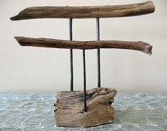 a piece of driftwood sitting on top of a table next to some metal rods