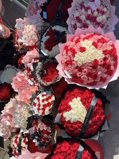 many red and white heart shaped cakes on display