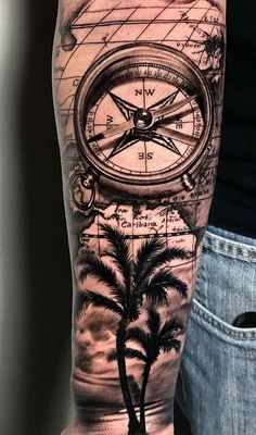 a man's arm with a compass and palm trees on it