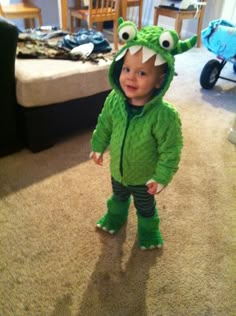 a toddler in a green frog costume