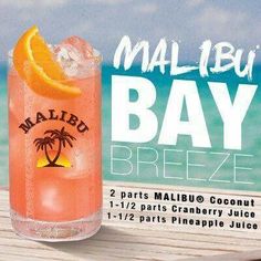 a close up of a drink on a wooden table near the ocean with an advertisement for malbu bay breeze