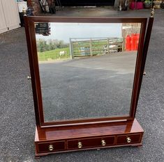 a mirror sitting on top of a wooden table