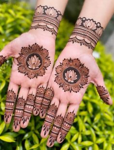 two hands with henna tattoos on them