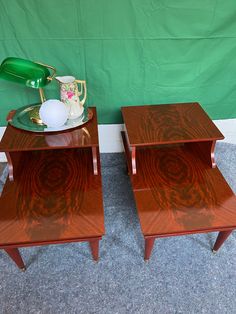 two wooden side tables sitting next to each other on top of a carpeted floor