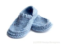 a pair of blue knitted slippers sitting on top of a white floor next to each other