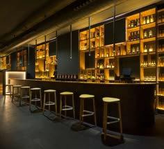 a dimly lit bar with stools in front of it