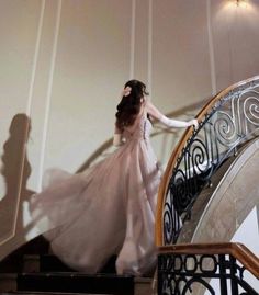 a woman in a dress is walking down the stairs