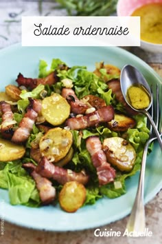 a blue plate topped with bacon, potatoes and lettuce next to a fork