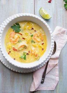 a bowl of coconut shrimp soup on a table