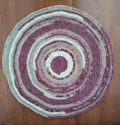 a purple and white round rug on top of a wooden floor next to a door