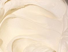 a bowl filled with white frosting sitting on top of a table