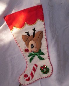 an embroidered christmas stocking with a reindeer on it