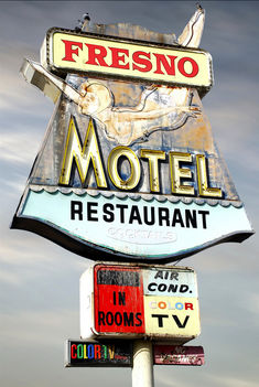 a sign for a restaurant that is on top of a pole in front of a cloudy sky