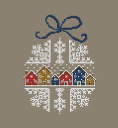 a cross stitch christmas ornament with houses and snowflakes