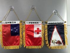 three flags hanging from hooks on a wall