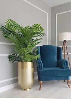 a chair next to a potted plant in a room