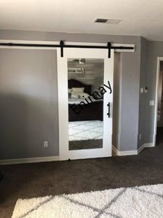 an empty bedroom with sliding doors and carpet