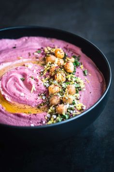 a black bowl filled with purple hummus and garnish