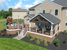 an aerial view of a house with a deck and swing set