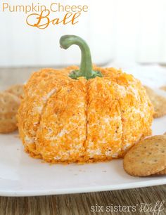 a pumpkin cheese ball is sitting on a plate with crackers next to it and the words, pumpkin cheese ball