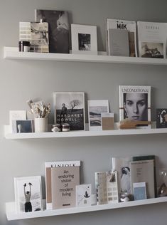 the shelves are filled with books, magazines and other decorative items in white painted shelving