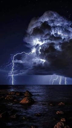 a storm is coming over the ocean and it looks like lightning has struck in the sky